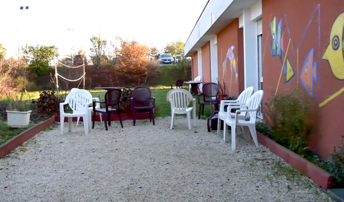 une court avec des chaises et un mur tagué 