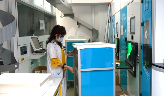 Une femme qui tient un chariot dans la pharmacie.