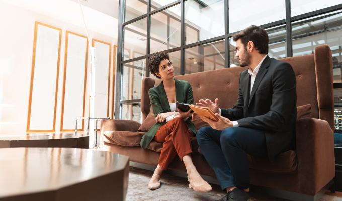 un homme et une femme qui discutent sur un canapé -