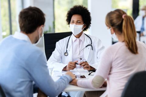 Une médecin en consultation avec un couple pour un PMA 