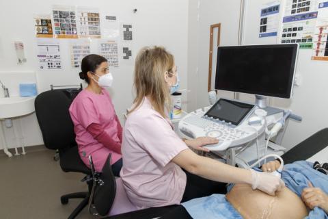 un gynécologue avec un infirmière qui pratiquent une échographie sur une femme enceinte 