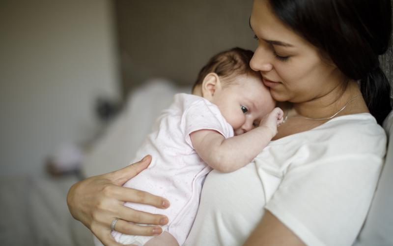 une femme qui tient son bébé dans les bras 