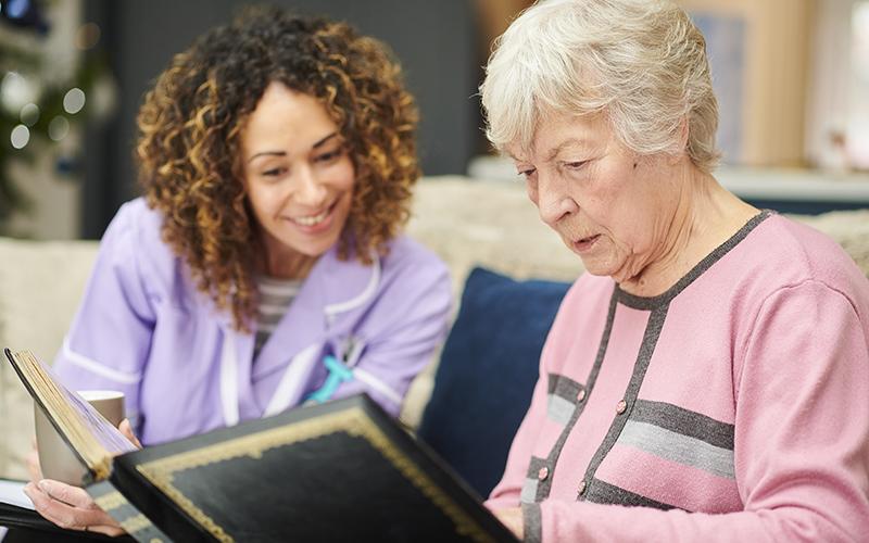 Une dame qui fait travailler la mémoire une personne âgée